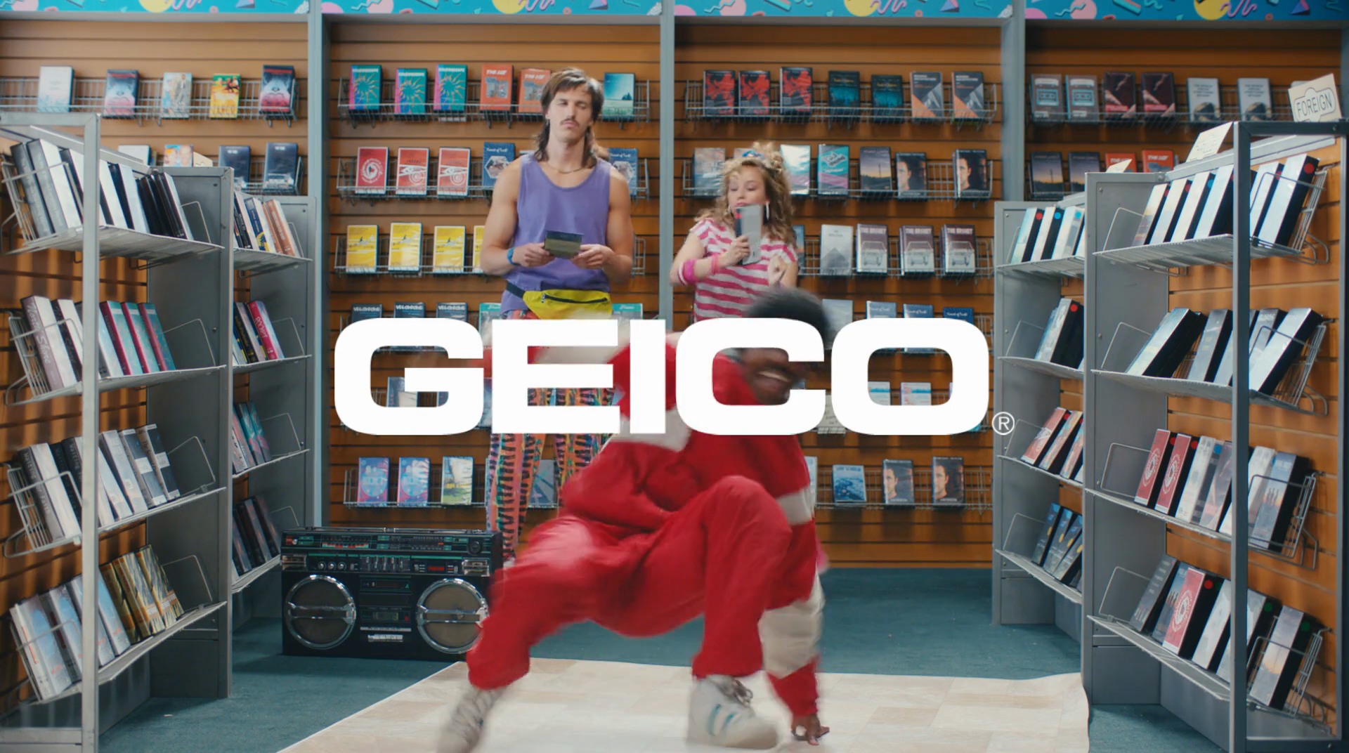The 80s audience — a breakdancer spins beside a couple browsing records