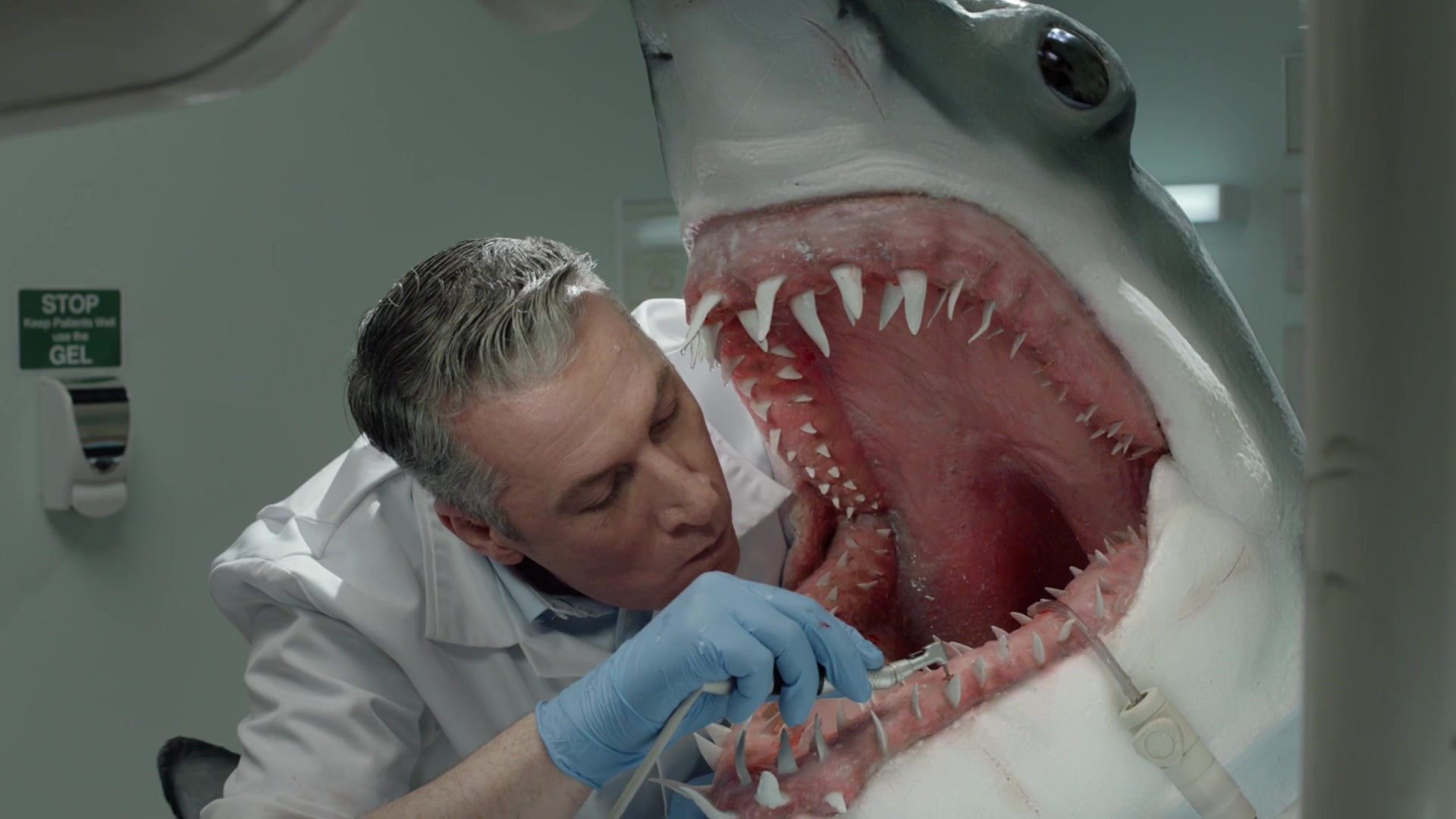 Dentist cleans teeth inside enormous open shark mouth