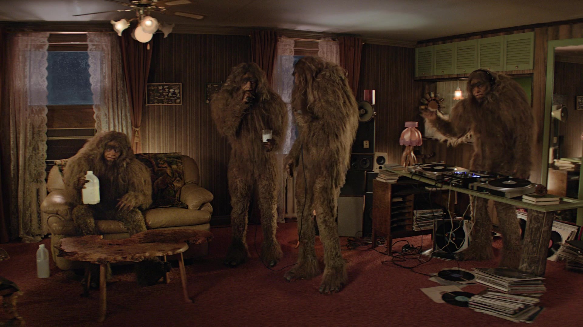 Noisy Neighbor — Four Sasquatches in a wood-paneled DJ room, milk jug and record player