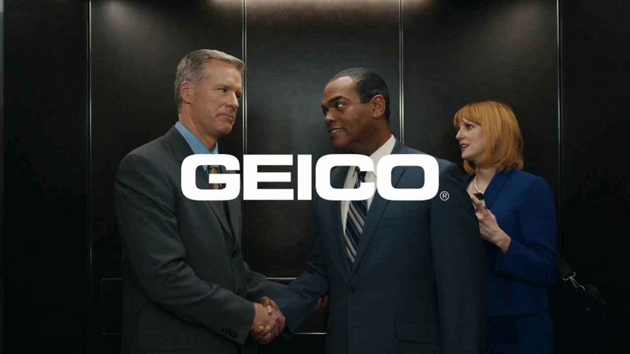 Elevator — a woman tries to squeeze past two men frozen in a handshake